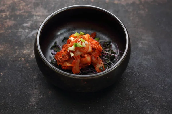 Ensalada coreana tradicional y picante de kimchi, sobre un fondo negro pedregoso. — Foto de Stock