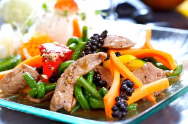 Kızarmış, doğu yemeği domuz eti, yeşil fasulye, havuç, kırmızı biber, cam tabakta servis edilir..