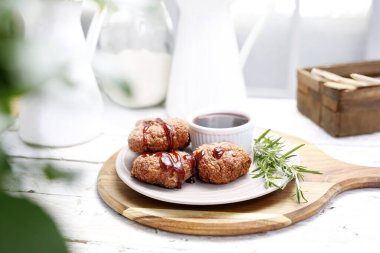 Kızarmış tavuk yahnisi, beyaz tabakta kümes hayvanları, tahta kesme tahtası. De Volaille, et köfteleri, hamburgerler, bonfile soslu pirzola, taze biberiyeyle süslenmiş..