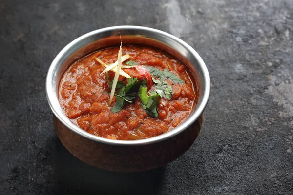 Zbliżenie vindaloo, curry, orientalne danie, na czarnym kamiennym tle. Tradycyjna indyjska kuchnia. Sos na bazie przecieru dyniowego, pomidora, cebuli, białego wina z kolendrą, mięsa, sera lub ryby. — Zdjęcie stockowe
