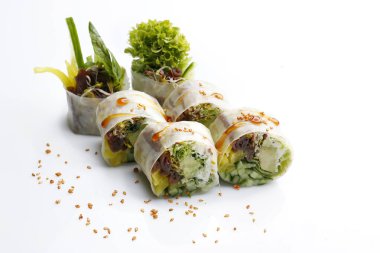 Taze sebzeli vegan börekleri, avokado, susamla süslenmiş, beyaz arka planda izole edilmiş. Pirinç kağıdında 6 parça suşi, Asyalı bir restoran menüsü için paket fotoğrafı..