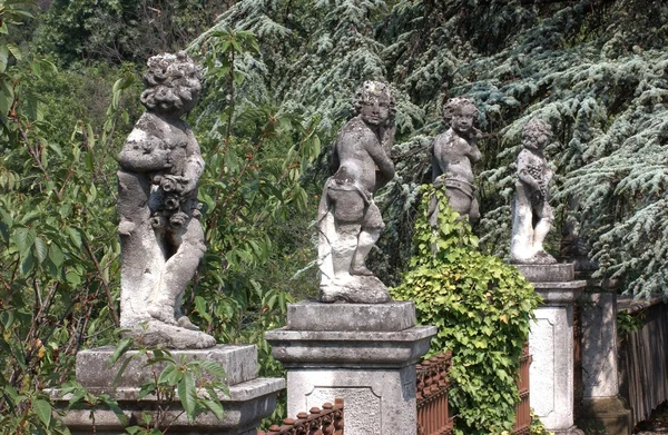 Старинные статуи и забор — стоковое фото