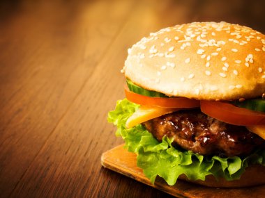 Bir ahşap tahta üzerinde sulu Burger