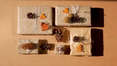 Noel 'i boşa harcamak, sert gölgelerle donatmak. El yapımı eko hediye, doğal yeni yıl jüt dekorasyonları üst manzara. Kraft kağıt ambalajı, plastik konsept olmadan. Turuncu ağaçlar, kalpler ve koniler 4K video