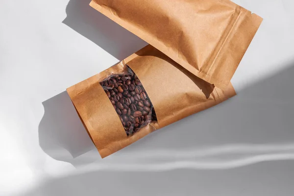 Kahverengi Kese Kağıtları Kahve Çekirdekli Çantalar Beyaz Arka Planda Gölgelenmiş — Stok fotoğraf
