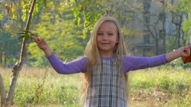 Девушка Длинными Светлыми Волосами Прыгает Природе Улыбающийся Ребенок Играет Осеннем — стоковое видео