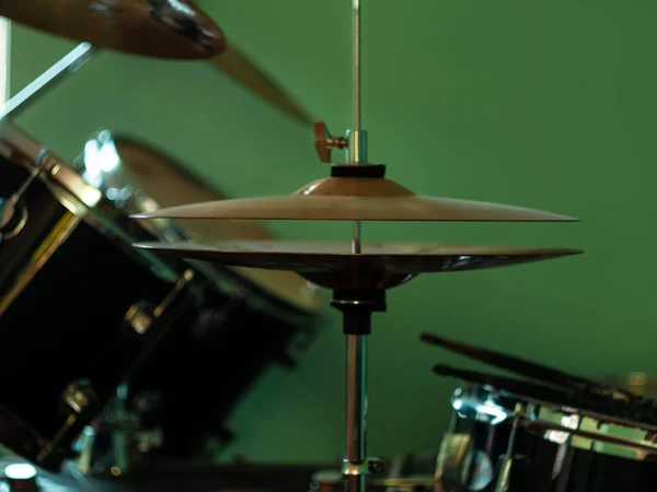 Black drum kit close-up. Musician set with mix of drums in studio. Musical instruments devices for drumming performance. Low key, dark and moody rock metal music style. Selective focus on cymbals.