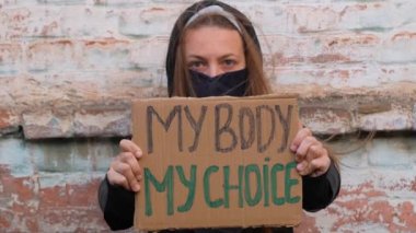 Genç kadın protestocu benim kartonum ve benim seçtiğim tabela taşıyor. Kürtaj karşıtı yasaları protesto eden bir kız. Feminist kadınlar güç yürüyüşü. Feminizm kavramı fırsat haklarına eşit özgürlük.