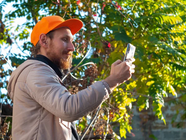 Молодий Червоний Бородатий Чоловік Розмовляє Мобільному Телефоні Посміхається Хлопець Плащі — стокове фото