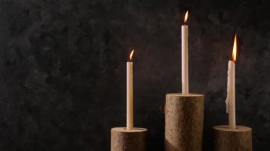 Sıfır atık konsepti, kahverengi masada doğal ahşap mum tutacakları. Karanlık arka planda mum yakmak. Spa sağlığı gevşemesi, çevre dostu ev tasarımı. Plastik iç dekorasyon yok.