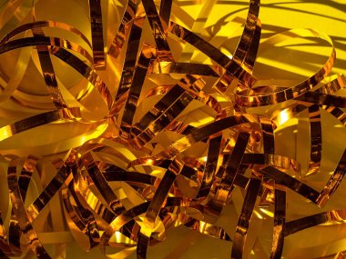 Şenlikli sarı arka plan. Altın parıldayan parlak kurdele deseni. Parlak süslemeler. Tatiller, yeni yıl Noel partisi, soyut, ışıltılı tebrik kartı pankartı şablonu.