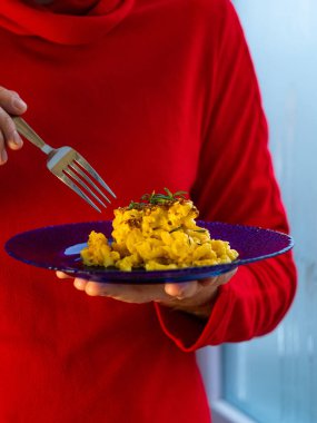 Makarna ve peynir, fırında makarna peynirli kremalı süt sosu Amerikan usulü ekmek kırıntısı. Ev yapımı kolay konforlu yemek tarifi. Mavi tabakta sıcak güveç, aşçının ellerinde..