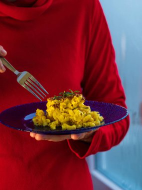 Makarna ve peynir, fırında makarna peynirli kremalı süt sosu Amerikan usulü ekmek kırıntısı. Ev yapımı kolay konforlu yemek tarifi. Mavi tabakta sıcak güveç, aşçının ellerinde..