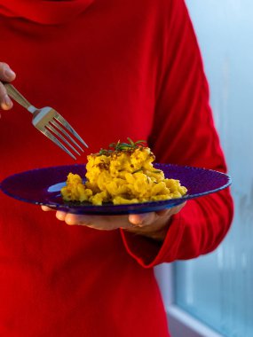 Makarna ve peynir, fırında makarna peynirli kremalı süt sosu Amerikan usulü ekmek kırıntısı. Ev yapımı kolay konforlu yemek tarifi. Mavi tabakta sıcak güveç, aşçının ellerinde..