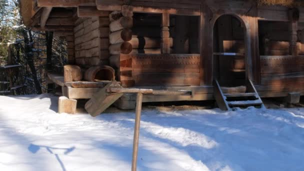 雪の多い冬の山の森の農村部の木造住宅の近くに装飾的な手作りの気象ベーン スキーリゾート家族のアクティブな休息 雪の冬の休日 気象用エアロバン 風向計又は風向計 — ストック動画