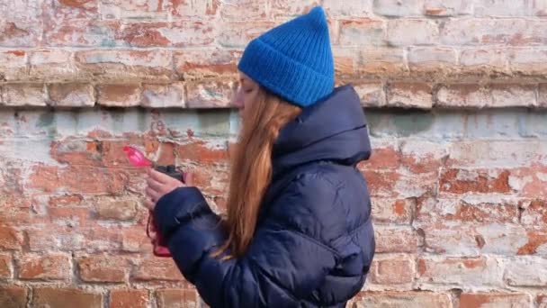 Молода Жінка Тримає Руці Рожеву Багаторазову Пляшку Води Міському Тлі — стокове відео