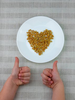 Çarşaf arka planında, çocuğun ellerinde filizlenmiş buğday. Makrobiyotik gıda vejetaryen yemeği filizlendirir. Sağlıklı beslenme konsepti. Baharda evde yetişen bitkiler. Taze filizler filizlenir, Protein zengini süper yiyecekler