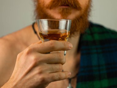 Geleneksel yeşil etekli İrlandalı sakallı adam elinde viski bardağıyla Aziz Patrick Günü 'nü kutluyor. Bıyıklı İskoç adam bar portresinde viski içiyor. 17 Mart İrlanda geçit töreni