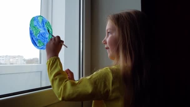 4Kの窓に惑星を描くかわいい女の子 ハッピーアースデイ4月22日挨拶メッセージ 創造的な家族のレジャーは新しい現実をロックダウン 生態系の保全環境に配慮した消費コンセプト — ストック動画