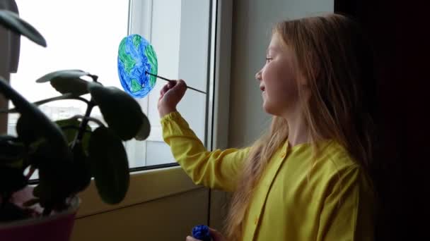 4Kの窓に惑星を描くかわいい女の子 ハッピーアースデイ4月22日挨拶メッセージ 創造的な家族のレジャーは新しい現実をロックダウン 生態系の保全環境に配慮した消費コンセプト — ストック動画