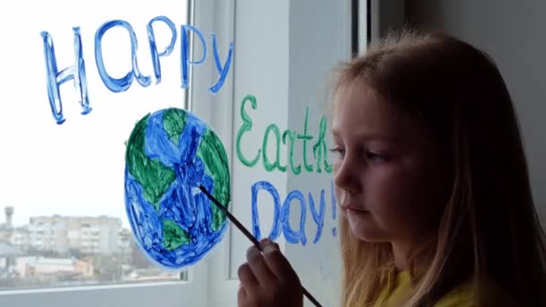 Cute Little Girl Malowanie Planety Oknie Domu Szczęśliwego Dnia Ziemi — Wideo stockowe