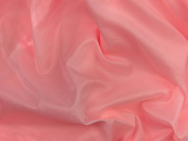 Pembe ipek kumaş üst görünüm. Kırmızı mercan parlak saten arka plan. Moda rengi kadın kıyafetleri modası. Kadın blog blog yazı arkaplanı tasarımı. Kız soyut duvar kağıdı pürüzsüz tekstil yüzeyi.