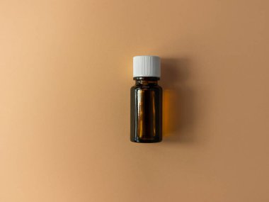 Bitki özlü cam şişe bej çiçekli arka plan. Alternatif tıp rahatlatıcı spa aromaterapi vücut tedavisi güzellik kozmetik ürün şablonu. Masaj yağı teni özü