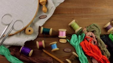 Çemberde keten işlemeli nakış işi. Renkli diş ipi, makas, kadın elinde kart etiketi. El yapımı etnik giysiler masa örtüsü. Yeni normal kilitlenme hobisi. Özel ders ilmekleri.