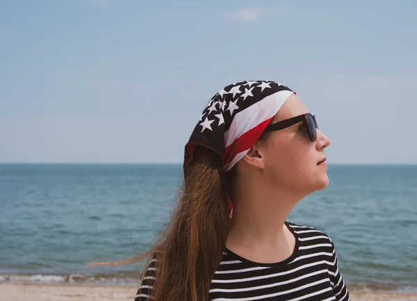 Confident girl in sunglasses american flag bandana. USA Independence Day patriotism concept, Memorial Day, national pride. Study English, US visa, Green card. Real authentic people lifestyle portrait.