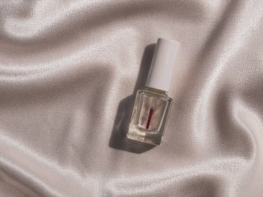 Beyaz ipek arka planda sert gölgeli tırnak cilası modeli Fransız manikür kozmetik ürünü. Yıkıma karşı şeffaf tırnak cilası ve makyaj malzemesi. Marka tasarım şablonu