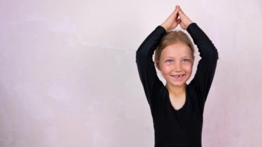 Siddhasana Lotus 'taki yoga sınıfındaki küçük kız gülümsüyor. Çevrimiçi esneme hareketleri çocuklar için, esneklik sağlık hizmetleri aktif yaşam tarzı sporu. 4K 'da sağlık eğitimi. Yeni normal