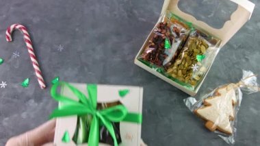Kız, ayrı ayrı paketlenmiş kurutulmuş meyve fındıklarıyla hediye paketini paketliyor. Sağlıklı beslenme. Noel kutlaması bayramları kadınların ellerinde eko-doğal atıştırmalıklar hazırlamak. Bilinçli tüketim tatlısı.