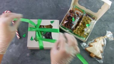 Kız, ayrı ayrı paketlenmiş kurutulmuş meyve fındıklarıyla hediye paketini paketliyor. Sağlıklı beslenme. Noel kutlaması bayramları kadınların ellerinde eko-doğal atıştırmalıklar hazırlamak. Bilinçli tüketim tatlısı.