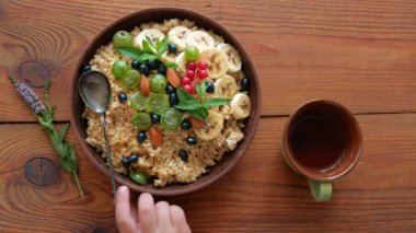 Taze böğürtlen, meyve, fındık ve nane yapraklı tam tahıllı yulaf lapası. Sağlıklı yemek yulaf ezmesi kahvaltı manzarası. Tahta masada tam tahıllı bektaşi üzümü üzümü üzümlü muz.
