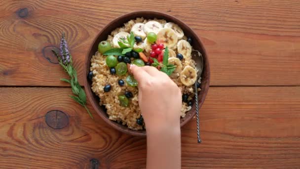 Volkoren Havermoutpap Met Verse Bessen Fruit Noten Muntblaadjes Kinderhanden Gezond — Stockvideo