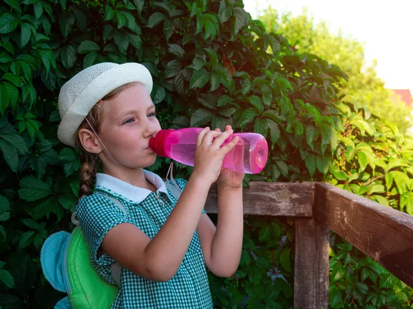 Şirin Liseli Kız Dışarıdaki Kullanılabilir Pembe Şişeden Içiyor Şapkalı Çocuk — Stok fotoğraf