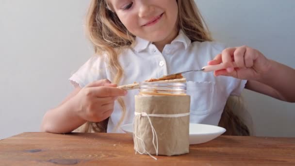 Bambino Mangiare Pane Croccante Con Burro Arachidi Seduto Tavola Cucina — Video Stock