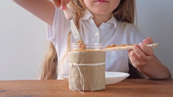 Niño Comiendo Pan Crujiente Con Mantequilla Maní Sentado Cocina Casa — Vídeos de Stock