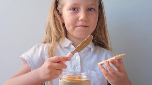 Bambino Mangiare Pane Croccante Con Burro Arachidi Seduto Tavola Cucina — Video Stock