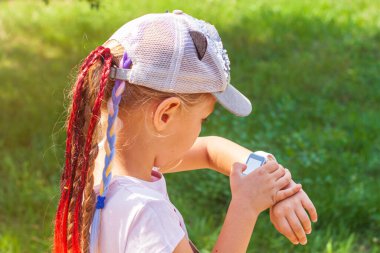 Akıllı çocuk parkını kullanan bir çocuk okulu öğrencisi. Çocuk vdeo görüşmesinde, ailesi akıllı adamlar ile konuşuyor. İnternette arama yapan öğrenci kız saatleri dokunmatik ekran görüntüsü kullanıyor. Kol saati GPS izleyicisi