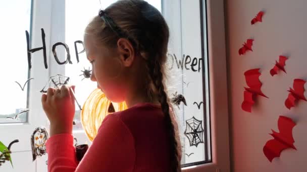 Kind Teufelshörnern Bemalt Kürbis Fenster Und Bereitet Sich Auf Halloween — Stockvideo