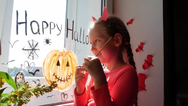 Kind Teufelshörnern Bemalt Kürbis Fenster Und Bereitet Sich Auf Halloween — Stockvideo