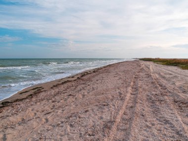 Güneşli bir günde mavi deniz ve gökyüzü arkaplanı olan boş bir sahil. Güney manzaralı duvar kâğıdı, sonbahar yaz tatili sezonu. Bulanık kopya alanı olan canlı mavi su. Tatil köyü reklamı