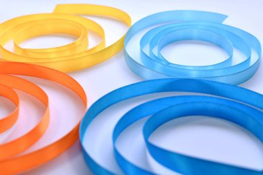  Saten kurdelelerden yapılmış bir kelebek parçası spiral şeklinde bükülmüş. Açık arkaplanda dört kanat.