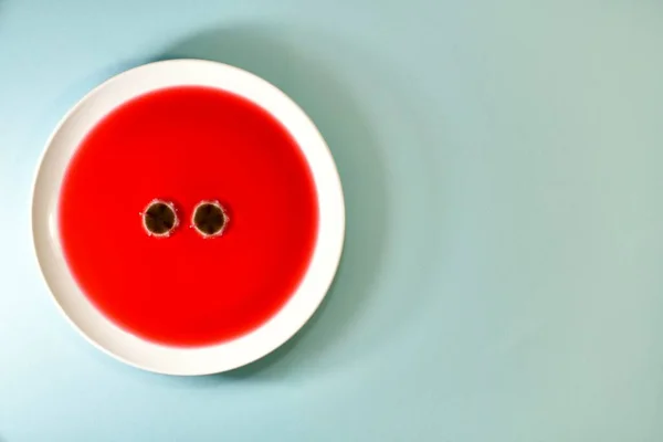 Dois olhos de fungo de molde, em uma chapa de chá de fruto. Esquerda em um fundo colorido de hortelã. — Fotografia de Stock