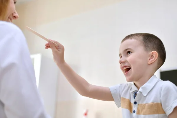 Bambino Sorridente Allegramente Tira Mano Con Una Spatola Medico Uniforme — Foto Stock