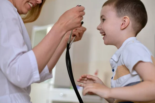 Den Kvinnliga Läkaren Bjuder Pojken Att Prova Sitt Stetoskop Kliniken — Stockfoto