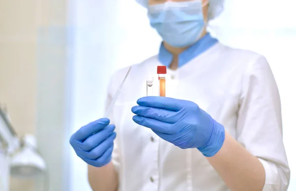 Plasma sanguíneo em um tubo de ensaio nas mãos de um profissional médico. Imagens Royalty-Free