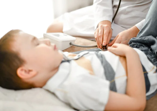 De arts meet de druk van een ziek kind met een tonometer. — Stockfoto