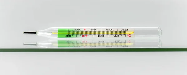 Thermometer liegt auf einer Glasoberfläche. — Stockfoto